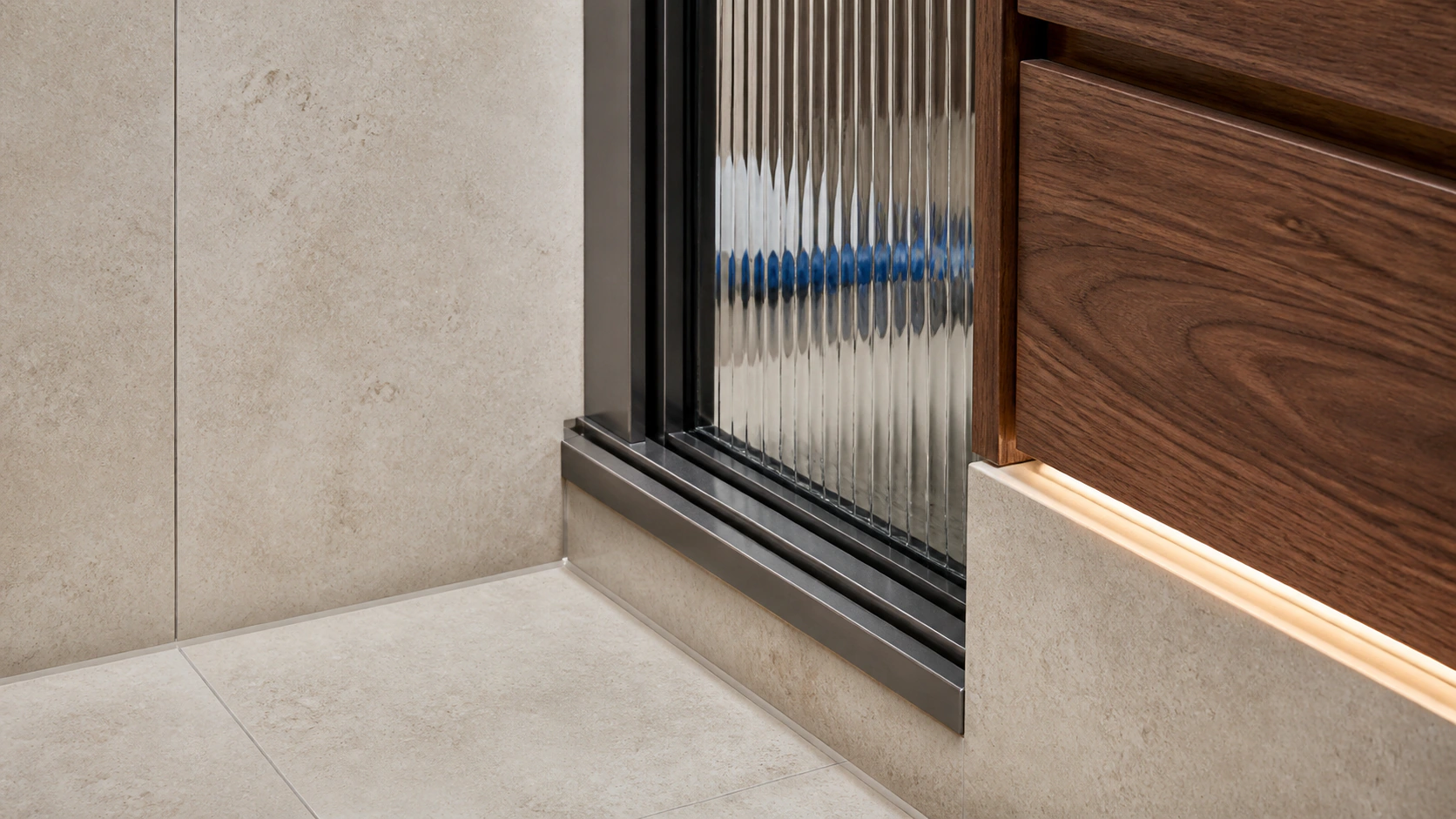 Conceptual close view of limestone, fluted glass, graphite metal and walnut meeting in a contemporary bathroom
